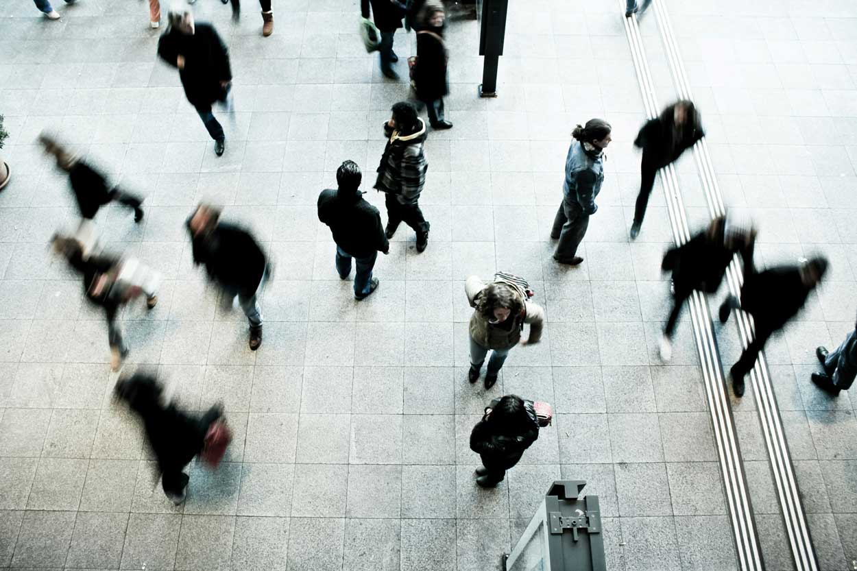 A bird's-eye view of a crowd of people walking on the street.