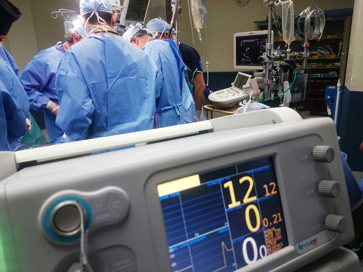 People in scrubs gathered around an operating table.
