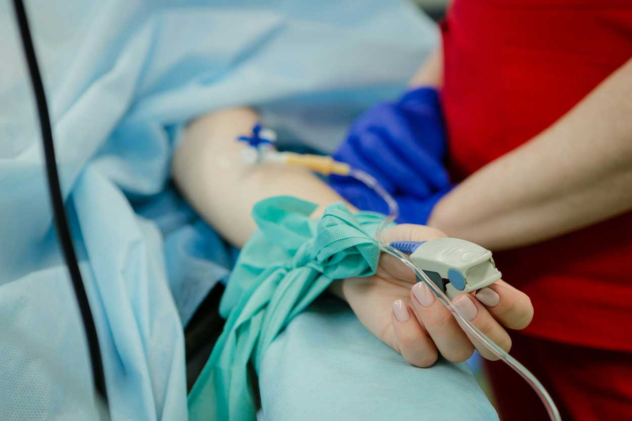 A closeup of a needle in a patient's arm.